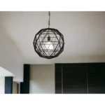 Close-up of the black metal geometric globe pendant light, highlighting the intricate wireframe pattern and bulb inside.