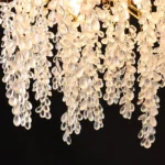 Gold crystal chandelier hanging in modern dining room with golden light reflections