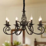 8-light rustic candle chandelier in black iron, hanging above a farmhouse kitchen island with pendant lights.
