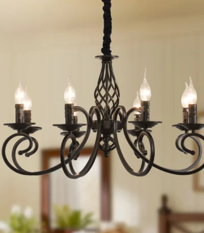8-light rustic candle chandelier in black iron, hanging above a farmhouse kitchen island with pendant lights.