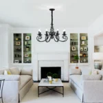 Detailed view of the chandelier's center column and decorative scrollwork, black iron material.