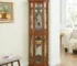 Lighted corner curio cabinet with glass shelves and door, showcasing collectibles