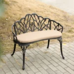 Black cast aluminum bench with floral rose design in a garden setting