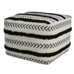 White striped storage ottoman in living room with books and decor on top