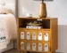 Natural wood nightstand with mirrored front and open shelf in a bedroom