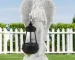Angel lantern statue glowing in garden at dusk