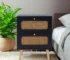 Minimalist bedside table with two handwoven rattan drawers in a bright bedroom