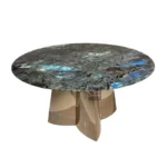 Modern round dining table with white marble top and gold stainless steel base in a bright dining room