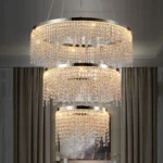 Modern 3-layer round K9 crystal pendant chandelier with 55W LED light, hanging in a foyer with warm glow.