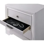 White nightstand with hidden drawer and nickel knobs beside a bed in a modern bedroom