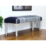 Blue gray upholstered bench with white legs in a living room setting