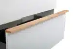 Close-up of white solid wood bathroom cabinet, wall-mounted, with soft-close door and handle detail.