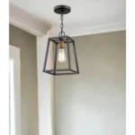 Close-up of the antique bronze finish and tapered silhouette of the HMS hanging light, with warm glass glow.