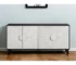 Distressed black sideboard with carved floral details in a living room setting