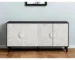 Distressed black sideboard with carved floral details in a living room setting