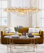 Modern crystal chandelier hanging in a dining room with gold finish and tree branch design