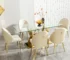 Modern dining table with clear glass top and stainless steel legs in a bright dining room