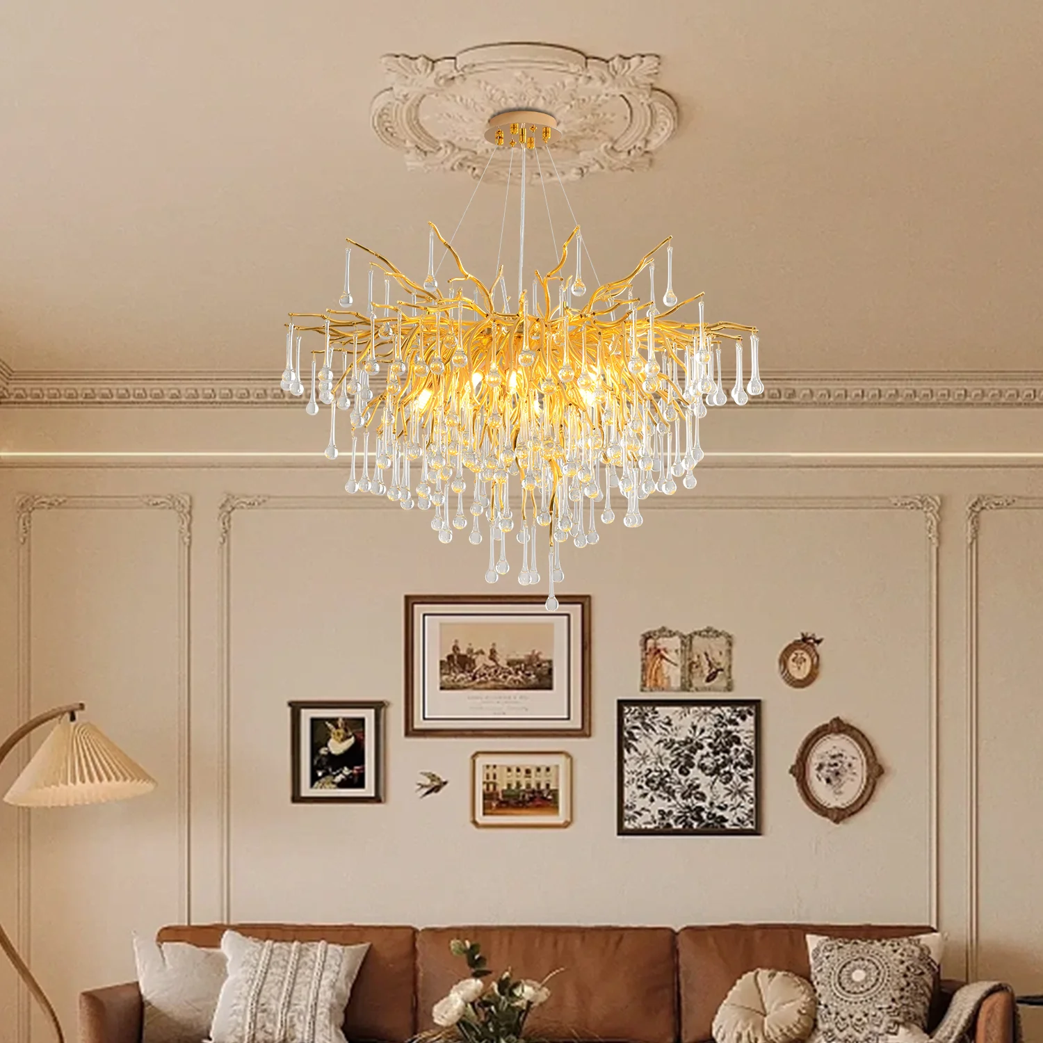 Modern crystal chandelier hanging in a dining room with gold finish and tree branch design
