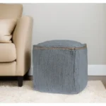 Goldoma foldable cube pouf ottoman in gray cotton with natural jute braid, placed in a living room as a footrest