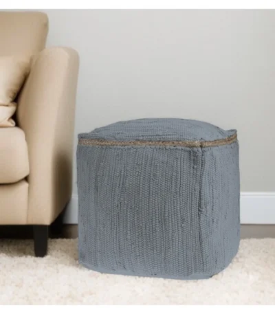 Goldoma foldable cube pouf ottoman in gray cotton with natural jute braid, placed in a living room as a footrest