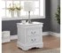 White nightstand with drawers in a bedroom setting