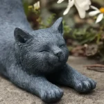 Hand-painted stretching cat statue in garden setting