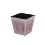 Side view of the recycled plastic planter showing the tone-on-tone design, placed on a table with outdoor background.
