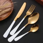 Elegant gold flatware set with fork, knife, and spoon on a white tablecloth