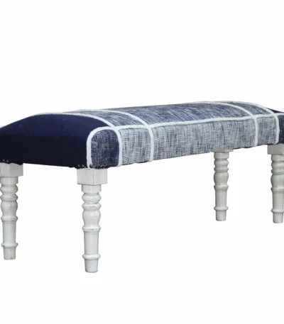 Blue gray upholstered bench with white legs in a living room setting
