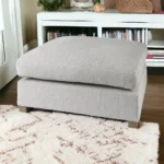 Goldoma light gray fabric cocktail ottoman with brown wood frame in living room