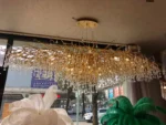 Modern crystal chandelier with brass and black finish illuminating a living room