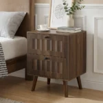 Modern double drawer nightstand with solid wood legs in walnut finish against a bedroom wall