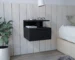 Black floating nightstand with drawer and open shelves mounted on wall