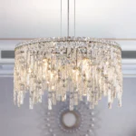 Polished chrome crystal pendant chandelier with 9 lights, 24-inch round canopy, hanging over a modern living room