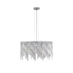 Polished chrome and crystal chandelier in a cozy living space, casting warm light over a sofa and coffee table.