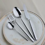 Goldoma 24-piece stainless steel cutlery set on a wooden table