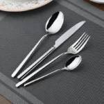 Goldoma 24-piece stainless steel cutlery set on a wooden table