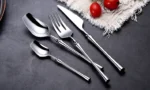 Matte black gold flatware set arranged on a table, showcasing elegant cutlery