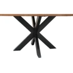 Rustic round dining table with natural acacia wood top and black iron pedestal base in a farmhouse dining room