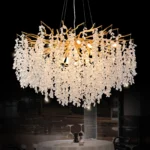 Gold crystal chandelier hanging in modern dining room with golden light reflections