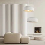 The light fixture shown in a bright living room with a neutral color palette, highlighting its organic shape and subtle