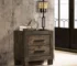 Rustic nightstand with two drawers in golden brown finish beside a bed