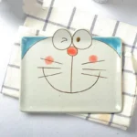 Japanese ceramic dinnerware set with hand-drawn cat design on blue rectangular plate and bowl