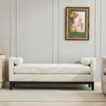 Goldoma upholstered bench daybed ottoman with wood legs and two bolster pillows in a modern living room setting
