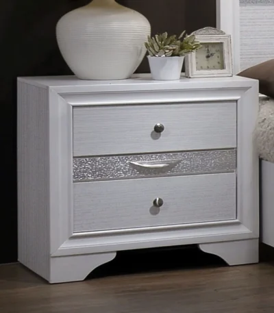 White nightstand with hidden drawer and nickel knobs beside a bed in a modern bedroom