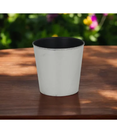 Large silver planter with a thriving houseplant on a modern table