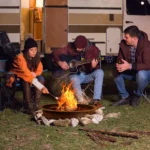 Portable camping fire pit with glowing flames in an outdoor setting
