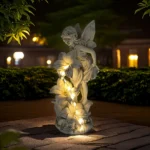 Solar fairy statue glowing in a garden at dusk