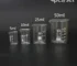 Set of four glass lab measuring cups with 5ml, 10ml, 25ml, and 50ml capacities arranged on a white surface