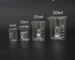 Set of four glass lab measuring cups with 5ml, 10ml, 25ml, and 50ml capacities arranged on a white surface
